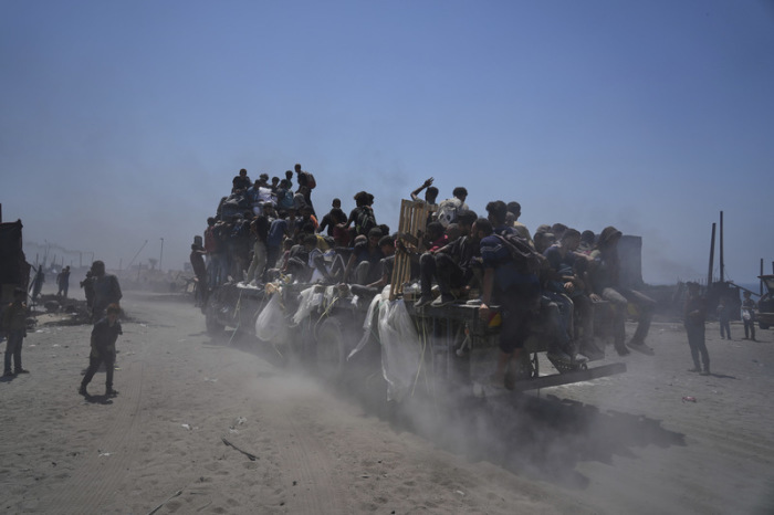 Palästinenser halten sich an einem Hilfstransporter fest, der aus dem nördlichen Gazastreifen nach Gaza-Stadt zurückkehrt. Foto: Abdel Kareem Hana/Ap/dpa