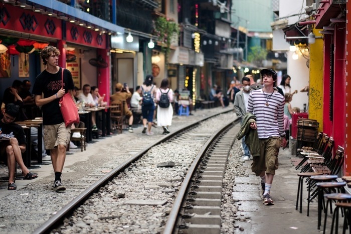 Touristen spazieren entlang der Bahnstrecke der berühmten „Train Street“ in Hanoi. Foto: epa/Luong Thai Linh