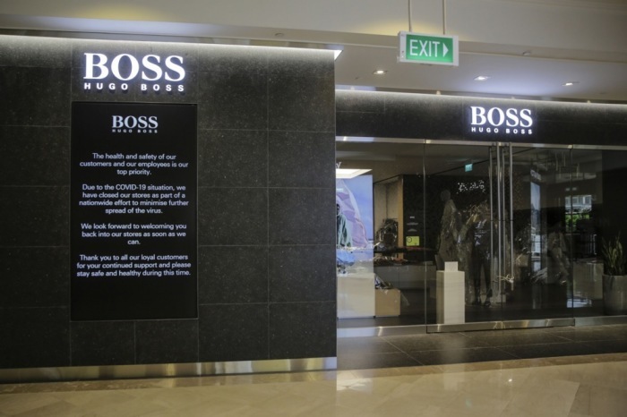 Elektronische Werbetafel mit Sicherheitshinweisen vor einem Hugo Boss-Geschäft in einem Einkaufszentrum in Singapur. Foto: epa/Wallace Woon