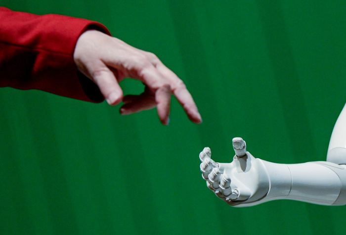 Ein Roboter interagiert beim «Speed Dating mit KI - Meet the Robots bei KI-Tagen» im Hammerbrooklyn Digital Campus mit einer Frau. Foto: Axel Heimken/dpa