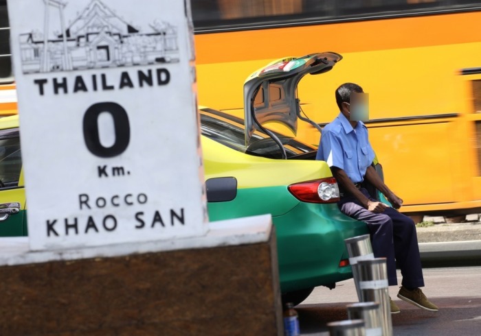 Ein Taxifahrer wartet in der Nähe des fast menschenleeren Touristenzentrums Khaosan Road in Bangkok auf Kunden. Foto: EPA-EFE/Narong Sangnak