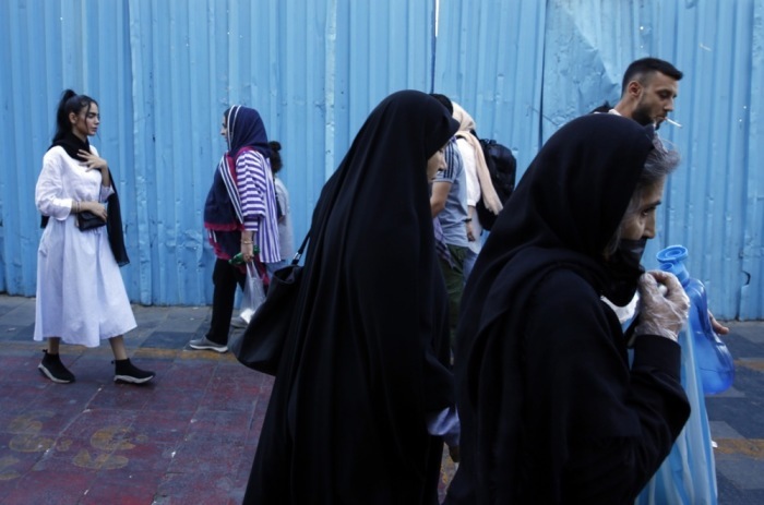 Iranische Frauen, einige ohne das vorgeschriebene Kopftuch, gehen in einer Straße in Teheran spazieren. Foto: epa/Abedin Taherkenareh