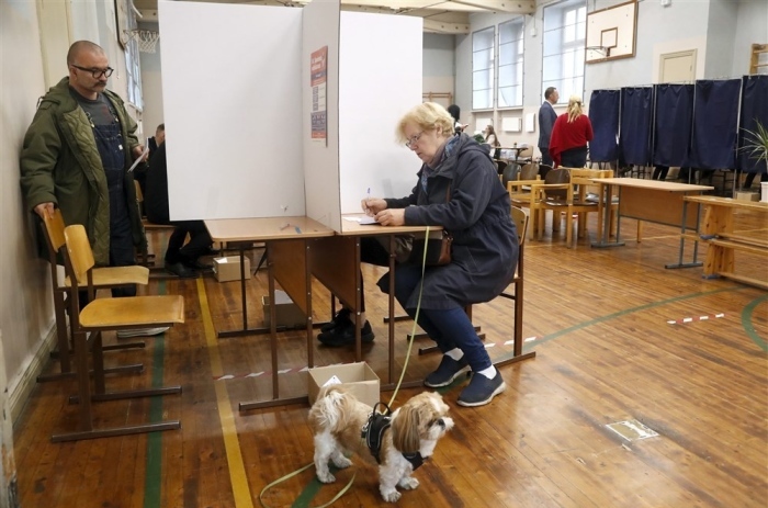 Eine Frau sitzt in einer Wahlkabine in einem Wahllokal während der Parlamentswahlen in Riga. Foto: epa/Toms Kalnins