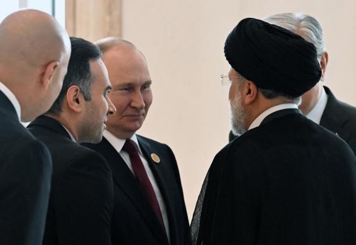 Der russische Präsident Wladimir Putin (C), hört dem iranischen Präsidenten Ebrahim Raisi (R) während eines Familienfotos zu. Foto: epa/Grigory Sysoyev