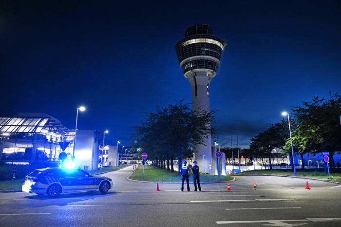 Polizei steht vor dem Tower des Münchner Flughafens. Am Flughafen München ist der Flugbetrieb teilweise eingestellt worden. Foto: Sven Hoppe/dpa
