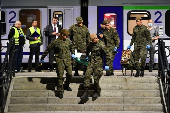 Polnische Armeeangehörige tragen verwundete Soldaten, die mit einem Sonderzug aus der Ukraine gekommen sind, zum Hauptbahnhof in Breslau. Foto: epa/Maciej Kulczynski