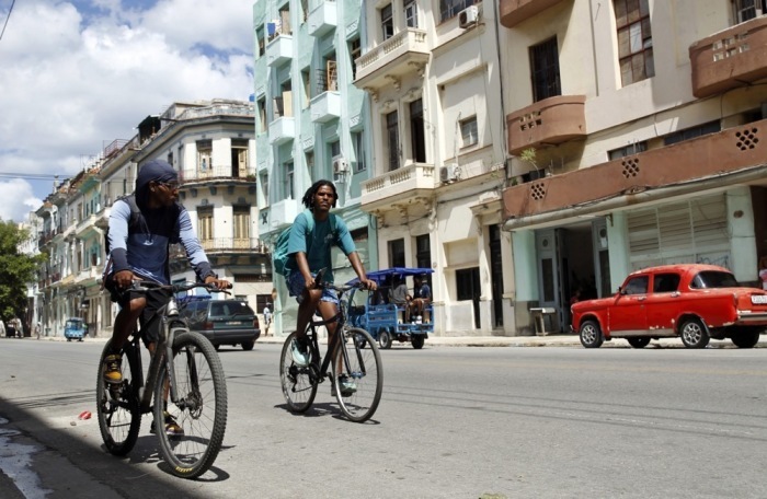 Menschen fahren mit Fahrrädern durch eine Straße in Havanna. Der Alltag in Kuba wird von den jüngsten Spannungen mit den USA überschattet. Foto: epa/Ernesto Mastrascusa