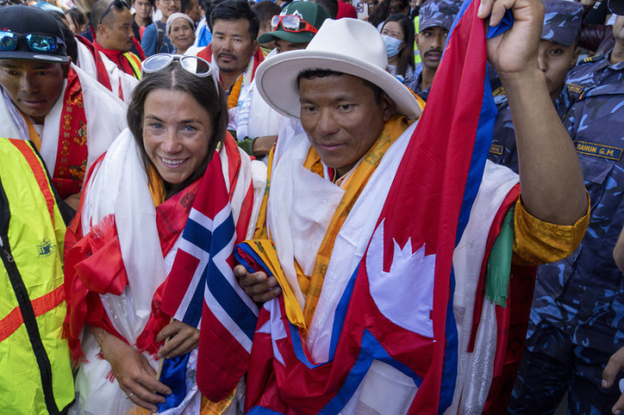 Kristin Harila (l), Bergsteigerin aus Norwegen, und Tenjen Sherpa (r), Sherpa-Führer aus Nepal, kommen in Kathmandu an. Foto: Niranjan Shrestha/Ap/dpa