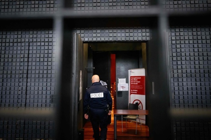Ein französischer Polizeibeamter betritt den Gerichtssaal in Nantes zum Prozess gegen den als „Maskenmann“ bekannten Deutschen. Foto: AFP/dpa/loic Venance