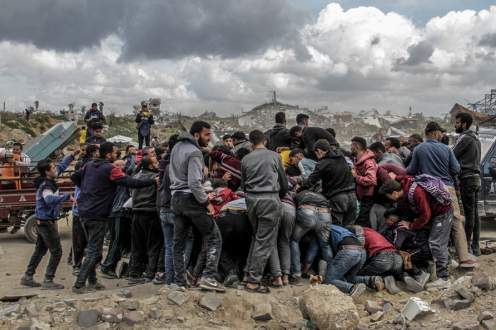 Menschen drängen sich um Pakete mit humanitärer Hilfe, die über dem nördlichen Gazastreifen abgeworfen wurden. Foto: Mahmoud Issa/dpa