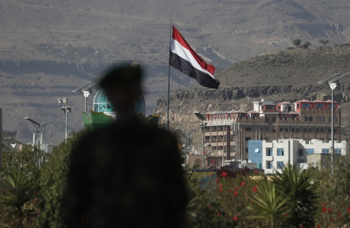Die Silhouette einer Person, die an einer wehenden jemenitischen Flagge in Sana'a vorbeigeht. Foto: EPA-EFE/Yahya Arhab