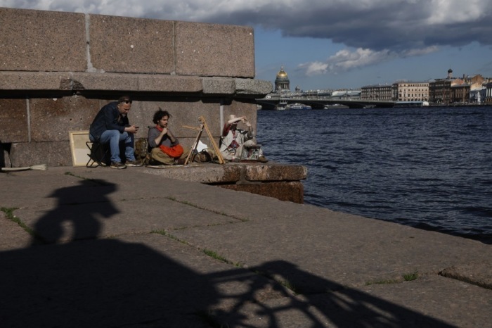 Künstler malen an der Uferpromenade Lieutenant Schmidt Embankment im Schatten des Denkmals für den russischen Admiral Ivan Kruzenshtern in St. Petersburg. Foto: EPA/Anatoly Maltsev