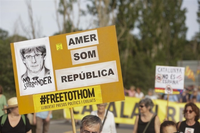Ein Demonstranten hält ein Plakat mit einem Foto des im Exil lebenden ehemaligen katalanischen Regierungschefs Carles Puigdemont. Foto: epa/Quique Garcia