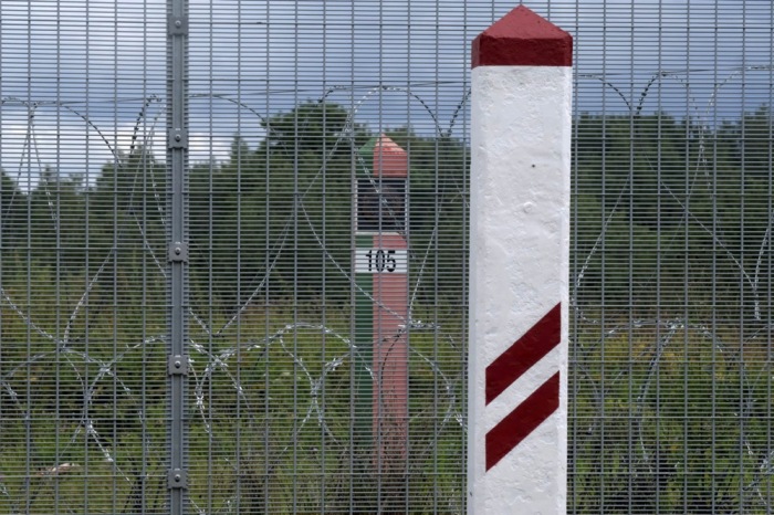 Der errichtete Zaun sowie lettische (R) und weißrussische Grenzschilder sind an der lettisch-weißrussischen Grenze in Robeznieki zu sehen. Foto: EPA-EFE/Valda Kalnina