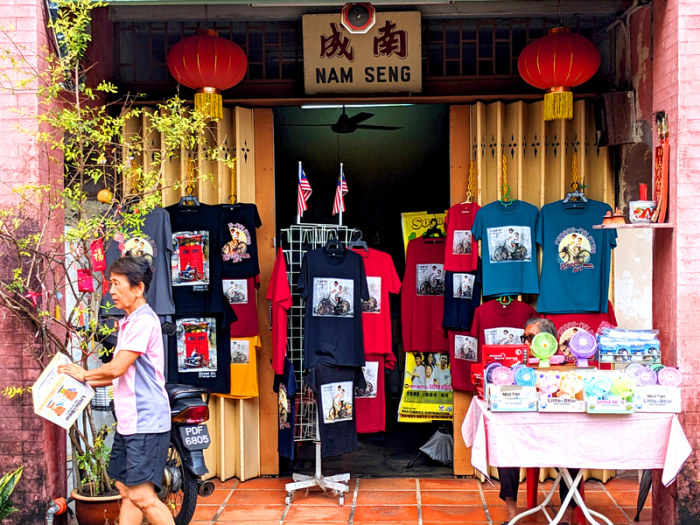 T-Shirts und andere Dinge, auf denen Street Art Kunstwerke aus Penang abgebildet sind, werden in einem Geschäft zum Kauf angeboten. Foto: Genevieve Tan Shu Thung/dpa