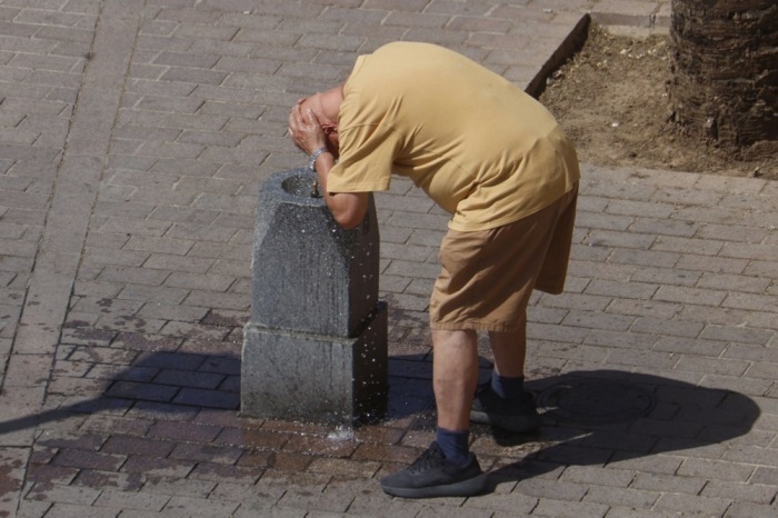 Ein Mann kühlt sich in einem Brunnen in Córdoba ab. Spanien bereitet sich auf Temperaturen von mehr als 40 Grad vor. Foto: EPA/Salas