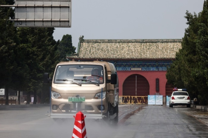Ein Rasensprenger bewässert den Vorplatz des Himmelstempels in Peking. Foto: EPA/Wu Hao