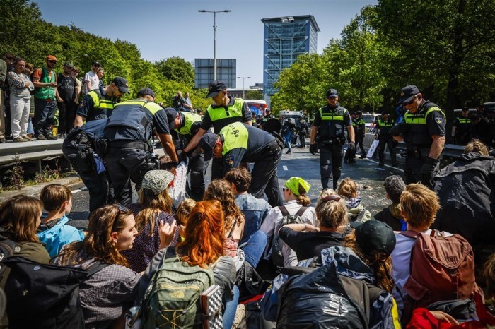 Die Polizei entfernt Aktivisten von Extinction Rebellion, die die A12 in Den Haag blockieren. Foto: epa/Sem Van Der Wal