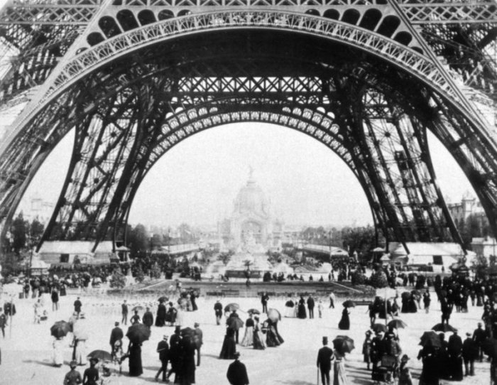 Das Archivbild zeigt Besucher der Weltausstellung von 1889 in Paris, die unter dem Eiffelturm - der damaligen Sensation - spazieren gehen. Foto: Fotoreport/Expo 2000 Hannover Gmbh/dpa