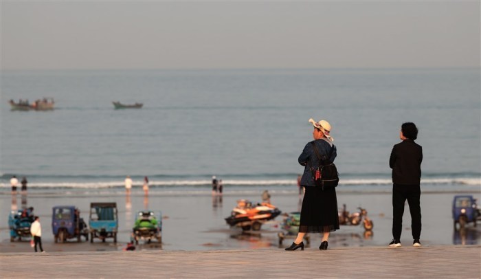 Leute stehen am Strand von Pingtan in der Provinz Fujian. Foto: epa/Alex Plavevski