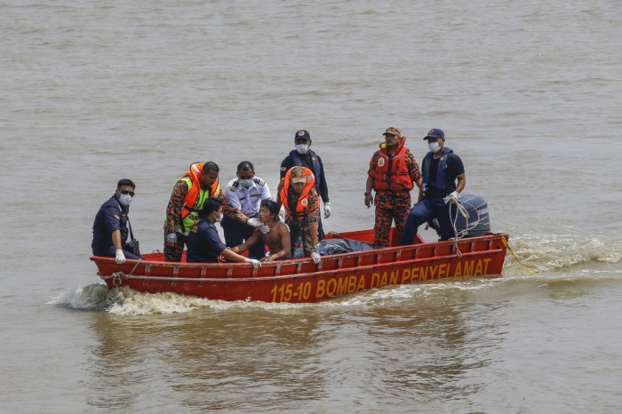 Rettungskräfte bringen einen Überlebenden an Land, nachdem vor der Küste Malaysias ein Boot mit Migranten gesunken war. Archivfoto: epa/Ahmad Yusni