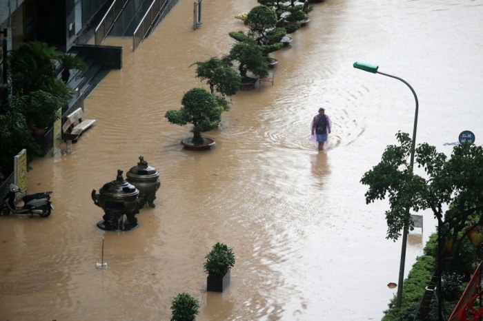 Ein Mann watet durch eine überflutete Straße in Hanoi, nachdem Taifun Matmo heftige Regenfälle über die Stadt gebracht hat. Foto: epa/Luong Thai Linh