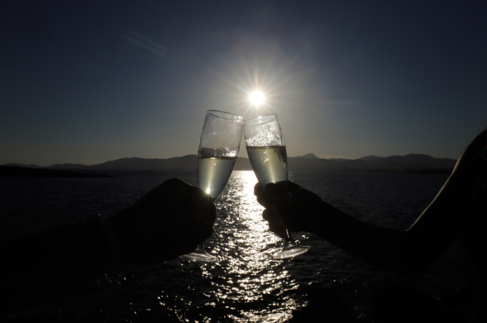 Ein Paar stößt bei Sonnenuntergang in der Bar Purobeach in Cala Estancia am Strand Playa de Palma mit Champagner an. Foto: Clara Margais/dpa