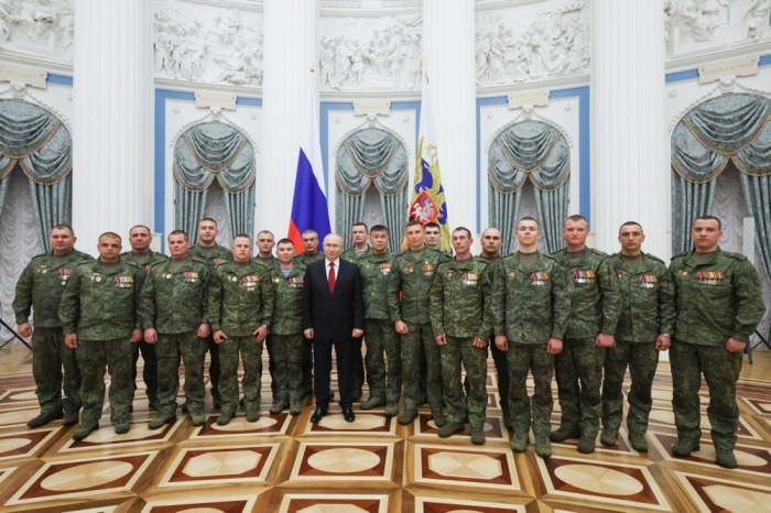 Präsident Vladimir Putin posiert im Kreml mit Teilnehmern des russischen Militäreinsatzes in der Ukraine während der Feierlichkeiten zum Russland-Tag in Moskau. Foto: Vyacheslav Prokofyev/Sputnik/kremlin Pool/epa/dpa