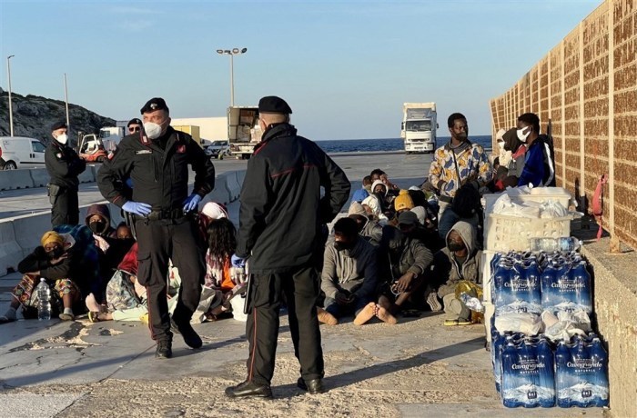 Migranten, die bereit sind, die Insel zu verlassen, warten auf die Fähre, die sie zu einem anderen Sammelzentrum außerhalb von Lampedusa bringen wird. Foto: epa/Elio Desiderio