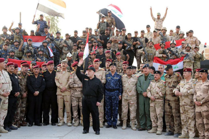  Der irakische Ministerpräsident (M.) erklärt vor Armeeangehörigen die Befreiung Mossuls. Foto: epa/Handout