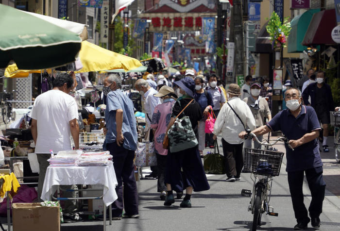 Leute schlendern durch Marktstände in einer Einkaufsstraße im Bezirk Sugamo in Tokio. Foto: epa/Franck Robichon