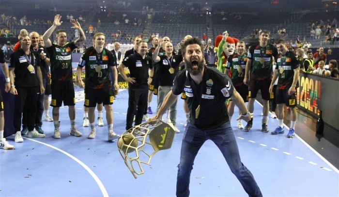 Der Magdeburger Cheftrainer Bennet Wiegert jubelt mit dem Pokal nach dem Sieg im Endspiel der EHF FINAL4 Handball Champions League. Foto: epa/Ronald Wittek