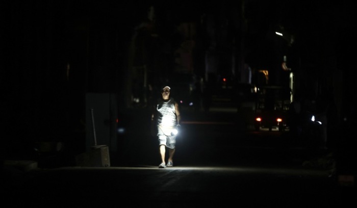 Ein Passant geht durch eine Straße in Havanna ohne Strom, während anhaltende Stromausfälle Kuba auch über die Feiertage belasten. Foto: epa/Ernesto Mastrascusa