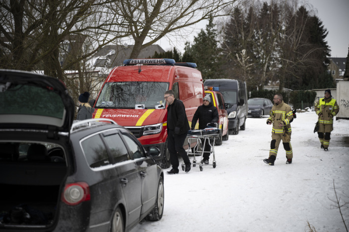 Bestatter bringen eine Trage zur Einsatzstelle in Wismar, wo bei der Suche nach einem verunglückten Eisbader die Leiche eines Mannes in einem Teich gefunden wurde. Foto: Philip Dulian/dpa
