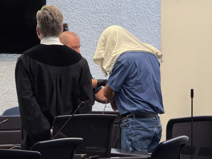Der angeklagte Kita-Betreiber mit verdecktem Gesicht und seinem Anwalt Bernd Kiefer im Gerichtssaal. Foto: dpa/David Nau