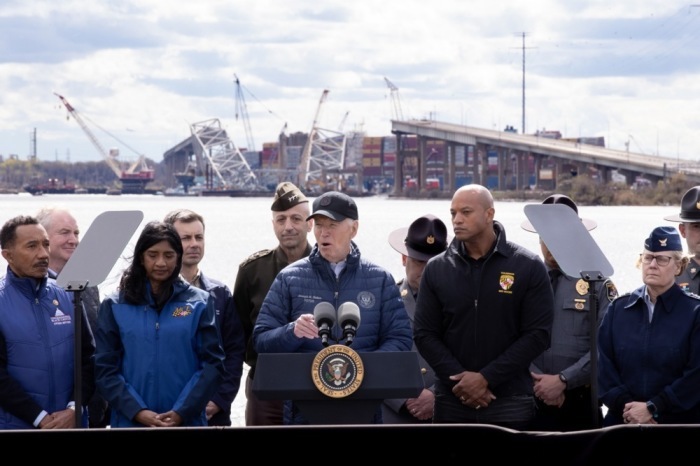 US-Kommissionspräsident Joe Biden (C) hält eine Rede in der Nähe des Wracks der Francis Scott Key Bridge (im Hintergrund) in Dundalk. Foto: epa/Michael Reynolds
