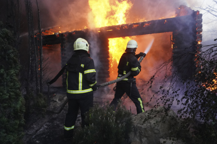 Feuerwehrleute löschen ein Feuer, nachdem ein Haus von russischem Beschuss getroffen wurde. Foto: Andrii Marienko/Ap/dpa